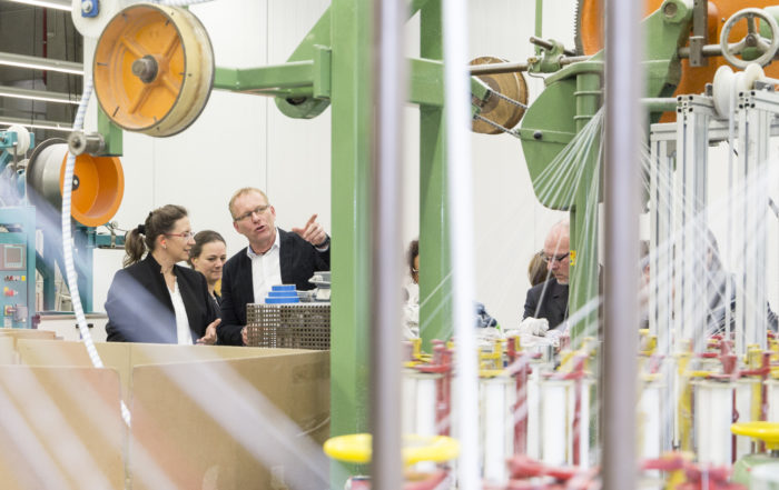 Mitglieder des Verbundprojekts AddiTex werden von JUMBO-Mitarbeiter Holger Vehring durch die Produktionshalle geführt.