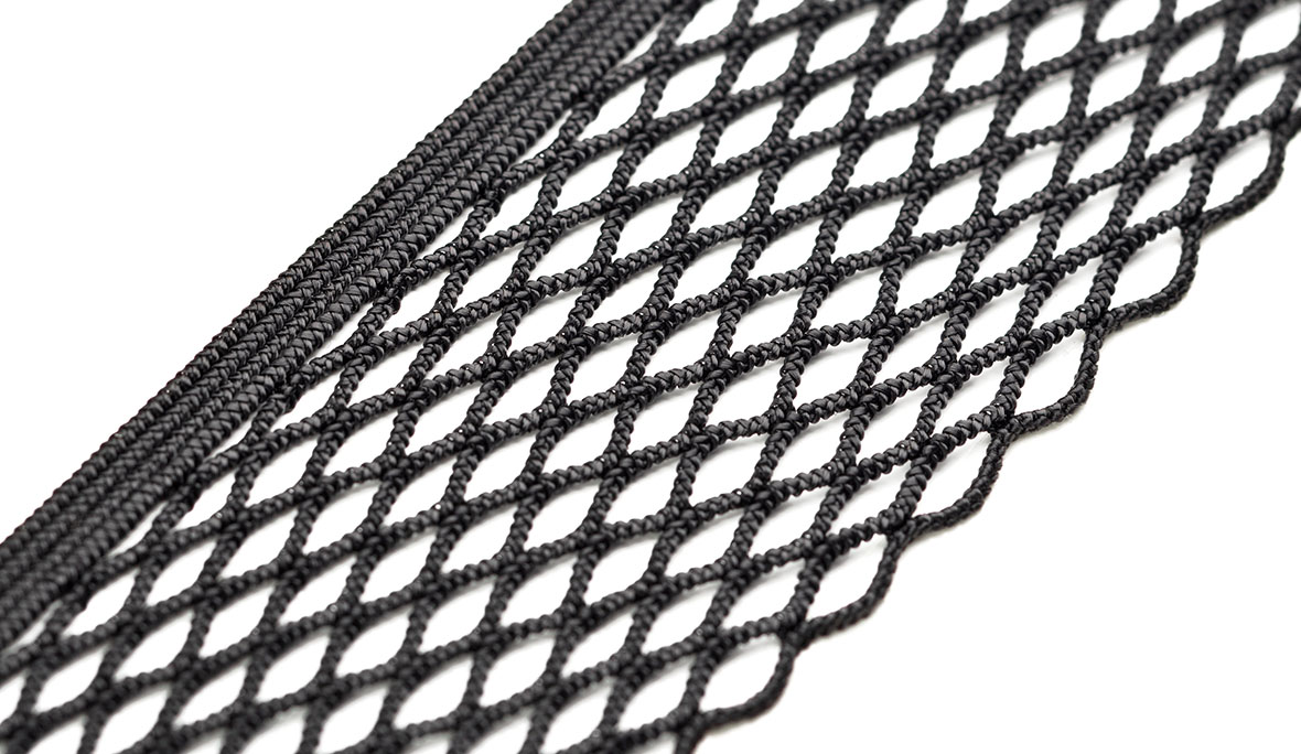 Ablagenetz: Produktfoto eines schwarzen elastischen Netzes, mit elastischer Häkelkante, vor weißem Hintergrund