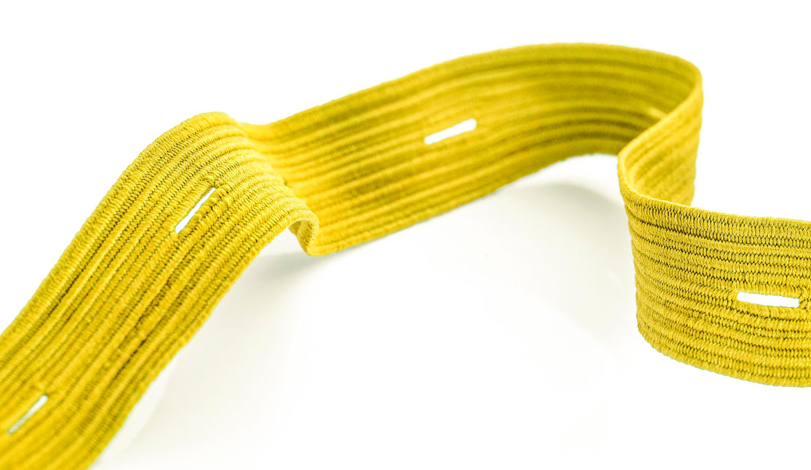 Geflochtene Knopflochgummilitze in Gelb auf weißem Hintergrund.