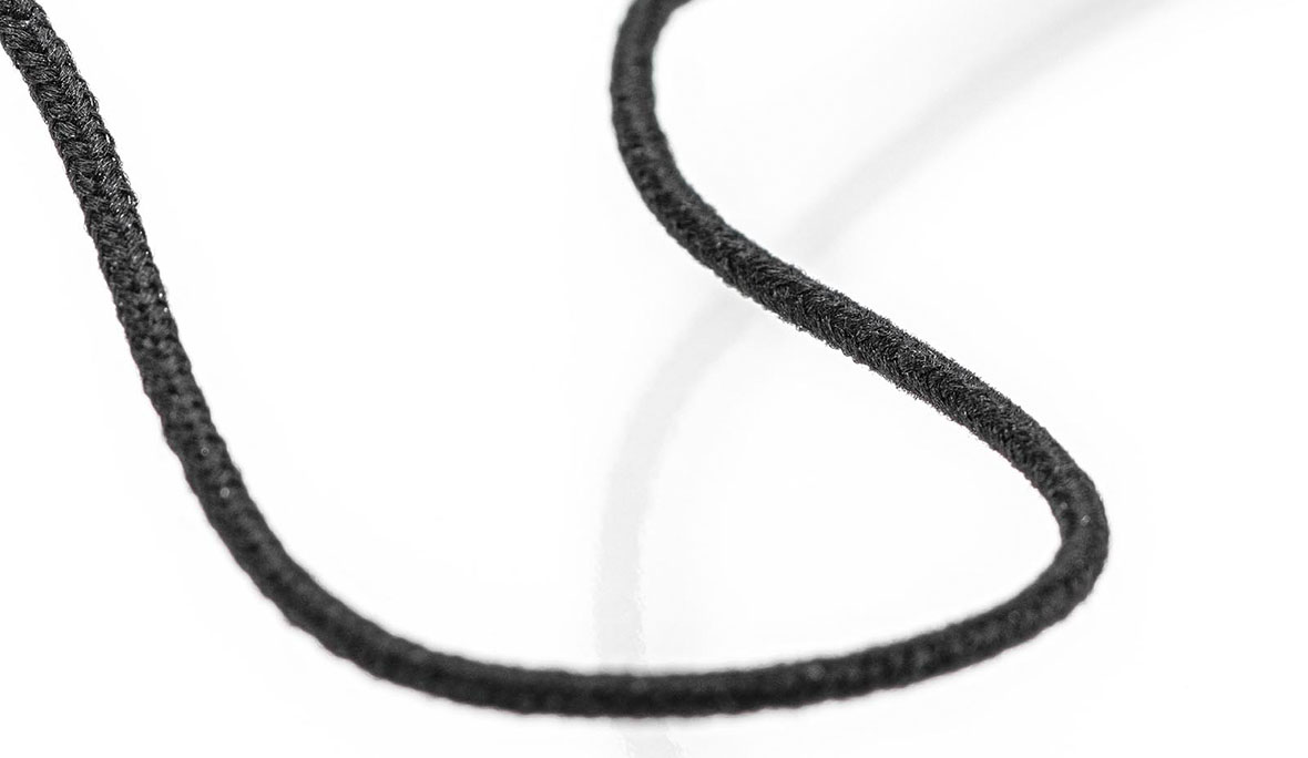 Nahaufnahme einer elektrisch leitfähigen Gummikordel in der Farbe Schwarz auf weißem Hintergrund.