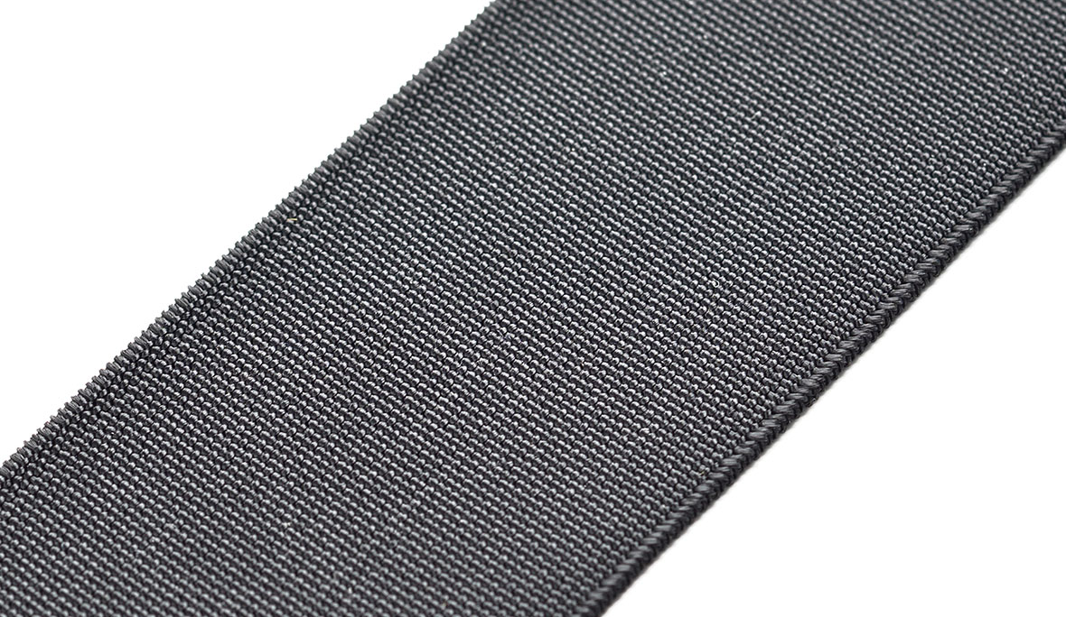 Ein gewebtes Elastikband in der Farbe Schwarz, über einen weißen Hintergrund gelegt.