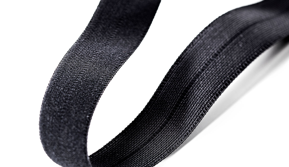 Schwarzes Webknickgummiband auf weißem Hintergrund.