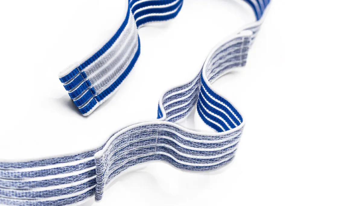Produktfoto eines blau-weißen und elastischen Klettbands auf weißem Hintergrund