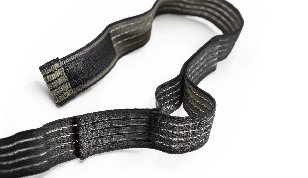 Klettfähiger Elastikgurt: Produktfoto eines schwarz- und olivfarbenen und elastischen Klettband auf weißem Hintergrund