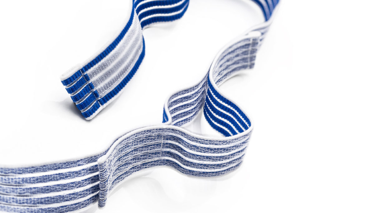 Klettfähiger Elastikgurt: Produktfoto eines blau-weißen und elastischen Klettbands auf weißem Hintergrund