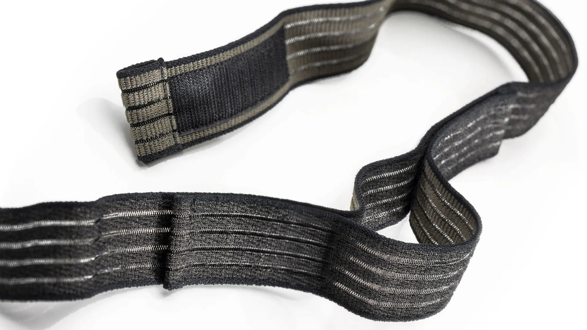 Produktfoto eines schwarz und olivfarbenen und elastischen Klettband auf weißem Hintergrund