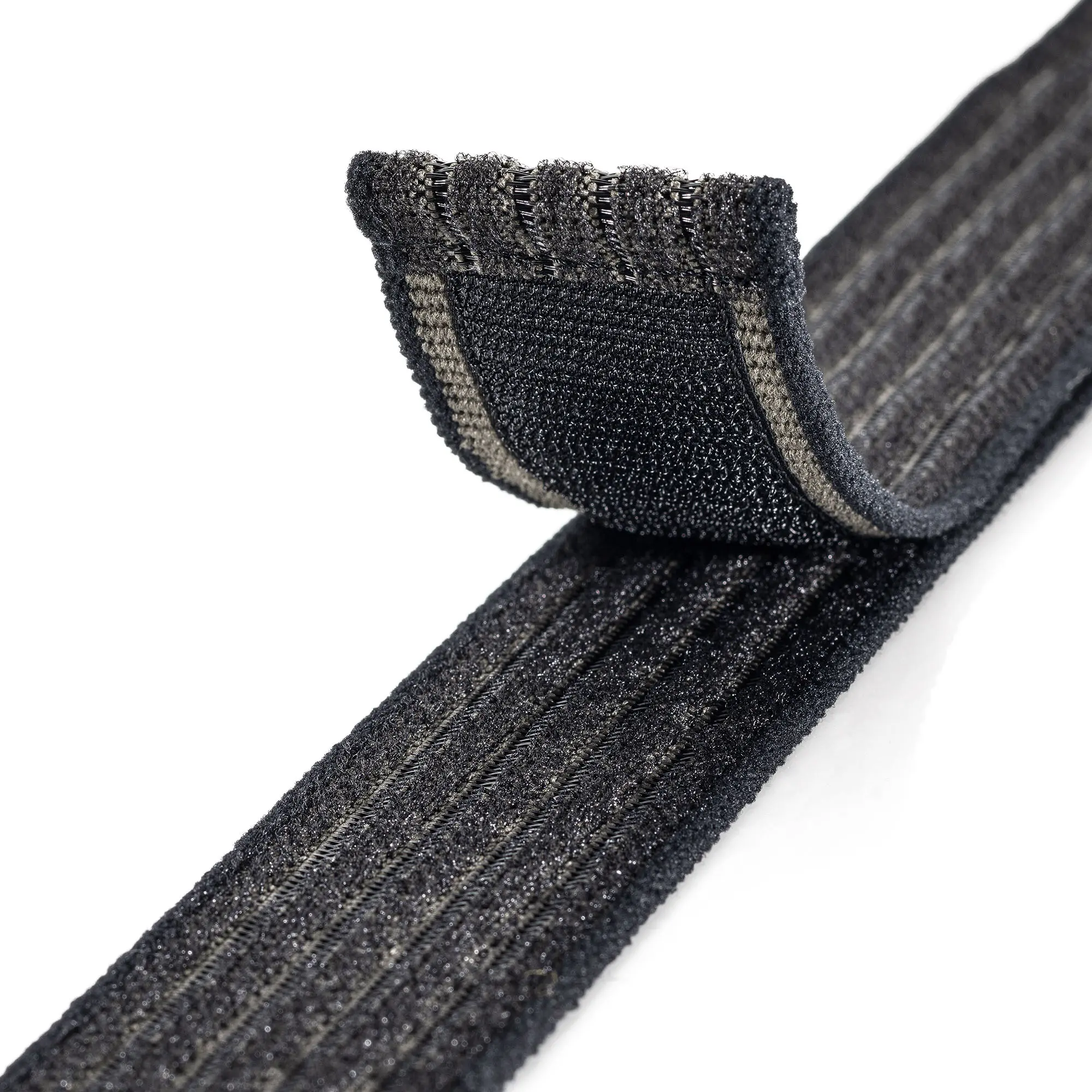 Produktfoto eines schwarz- und olivfarbenen und elastischen Klettband auf weißem Hintergrund, der Teil mit dem Klett ist nach oben gebogen