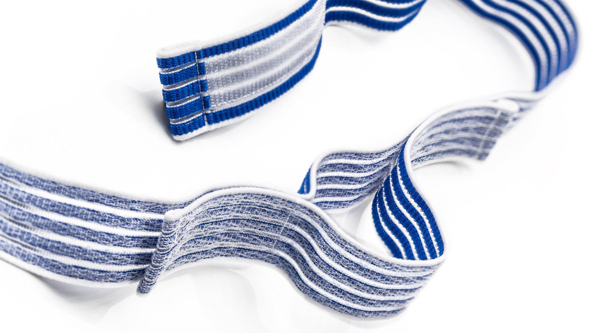 Klettfähiger Elastikgurt: Produktfoto eines blau-weißen und elastischen Klettband auf weißem Hintergrund